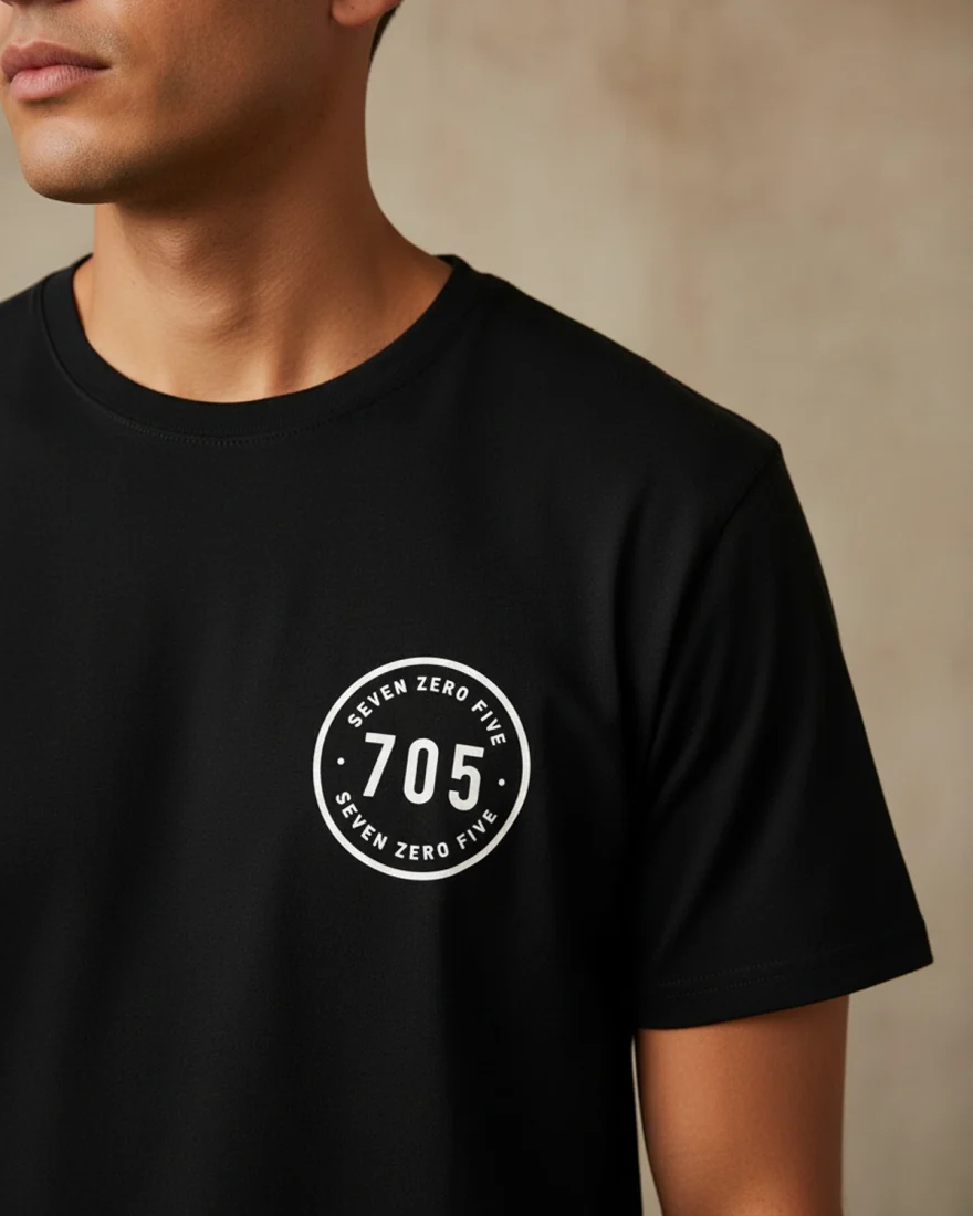 The tee worn by a model against a plaster wall.